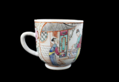Side 2 of scenery teacup: White scenery teacup illustrated with scene of figures beside two houses. One of the houses has an open door.