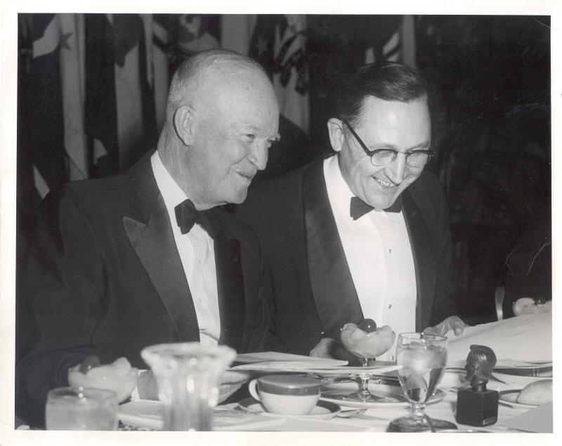 Black and white photo of Schwengel with Eisenhower sitting at a table at a banquet.