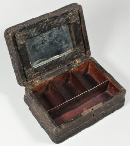 This wooden jewelry box with molded ornamentation on the exterior (HF.43.41) was used to keep brooches and jewelry put away.