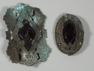 These brass brooches with purple paste stones (HF.43.41c,d) were worn for decoration.