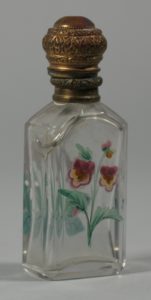 This small glass cologne bottle with painted flowers and a gold hinged lid (HF.1.46) was used to store cologne or perfume.